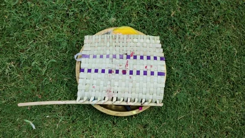 Bamboo hand fan placed on brass worship plate over green grass background o.. Stock Footage 335742737