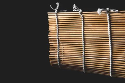 Bamboo mat for rolls on a dark background. Stock Photos