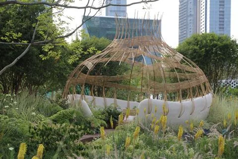 A bamboo pavilion in the shape of an egg, with white walls and a green roof.. Stock Photos