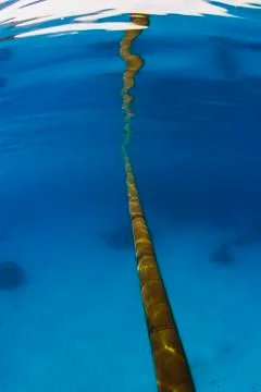 Bamboo pole reflection in ocean surface over a sandy bottom Stock Photos