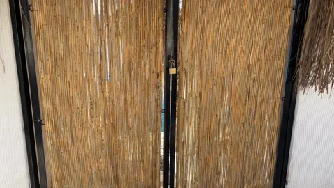 Bamboo privacy screen with metal frame casting shadows on floor, blending n.. Stock Footage 331154989