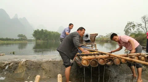 Bamboo raft drivers drag bamboo rafts up... | Stock Video | Pond5