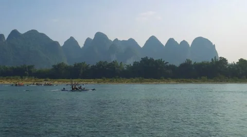 Bamboo rafts flowing through the idyllic rural landscape of Yangshuo Stock Footage 64829143