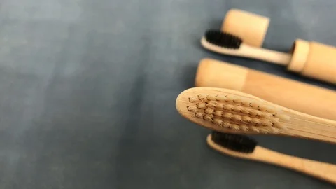 Bamboo toothbrush demonstration on grey background Stock Footage 113049270
