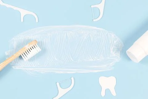 Bamboo toothbrush with smeared toothpaste, dental floss and paper tooth on a  스톡 사진