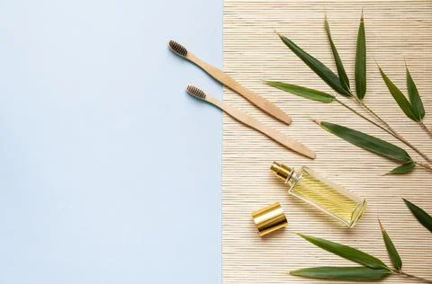 Bamboo toothbrush on a table with copy space on a blue background. Styled Stock Photos