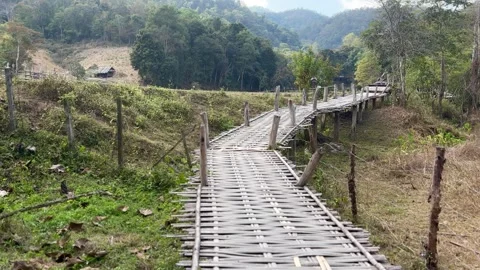 Bamboo Walkway Winding Through Mae Hi Valley Toward a Hillside Hut in Pai Stock Footage 345332587