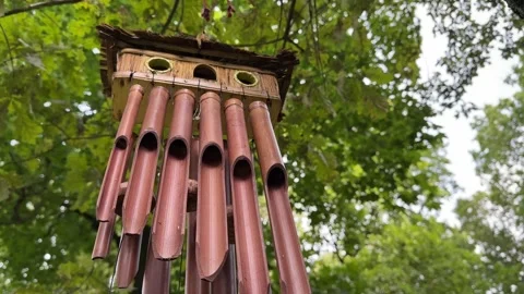 Bamboo Wind Chime Swaying Beneath Green Tree Canopy Video stock 343445142