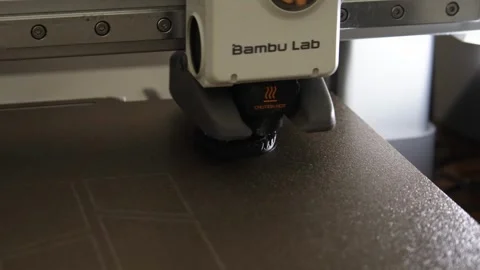 Bambu Lab 3D Printer Printing a Black Precision Component on Textured PEI Plate Stockbeeldmateriaal 333020232