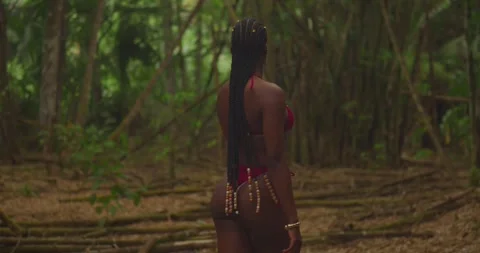 With bammboo and forest area in the background, a dark-skinned girl in a bikini Stock Footage 333614319