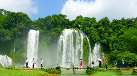 Ban Gioc Waterfall - May 2015: Visitors crossing wooden bridge by the waterfall. Stock Footage 52951245