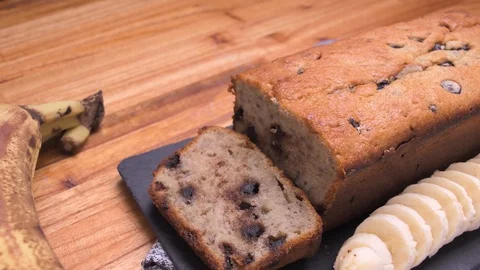 Banana Bread And Chocolate Portion Pan Close Up On Black Slate With Bananas Video stock 128093346