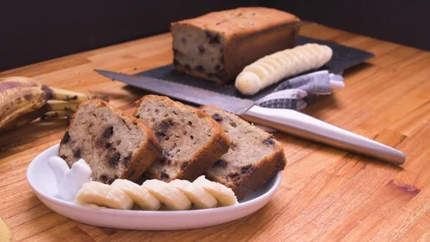 Banana Bread And Chocolate Three Portions on White Plate Close Up Over Wood Video stock 128093236