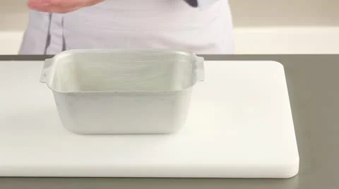 Banana bread dough being transferred to a loaf tin Stock Footage 24672416