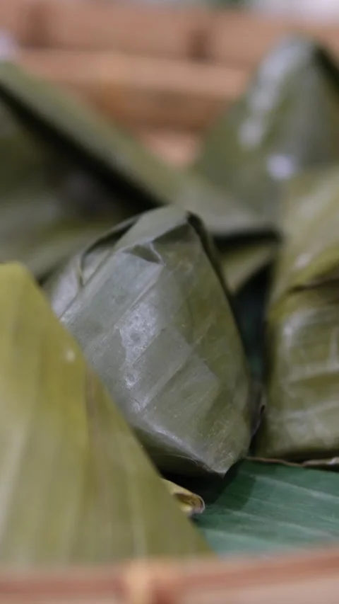 Banana leaf wrapper rotating on isolated white. metal steamer, common in Stock Footage 310156073