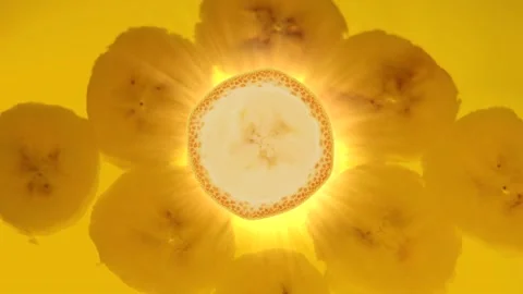 Banana on a yellow background. Rays of light. Rotating slice. Stock Footage 216910803