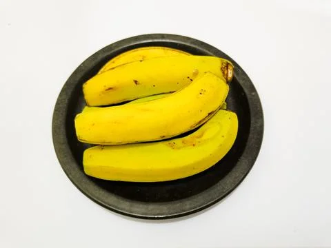Bananas on the black earthenware plate Stock Photos