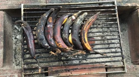 Bananas cooking over a fire barbeque Stock Footage 68856769