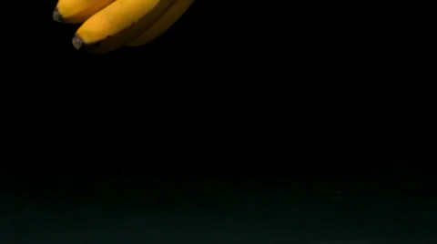 Bananas falling on black background | Stock Video | Pond5
