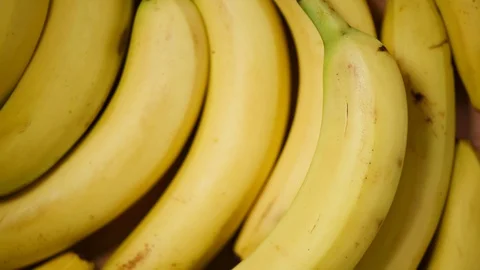 Bananas on rotating background. Top view. Vegan and raw food concept. Bunch of Stock Footage 125354369