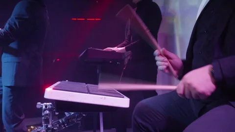 Band members perform energetically on stage with purple lighting motion blur and Stock Footage 322094748