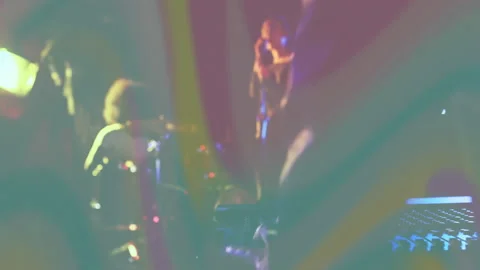 Band performing under haze with animated audio bars while tech adjusting mixer Stock Footage 307708481