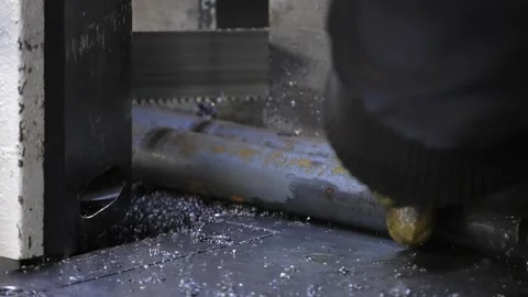 The band saw machine cutting raw metals rods the with the coolant fluid. Video stock 101777387