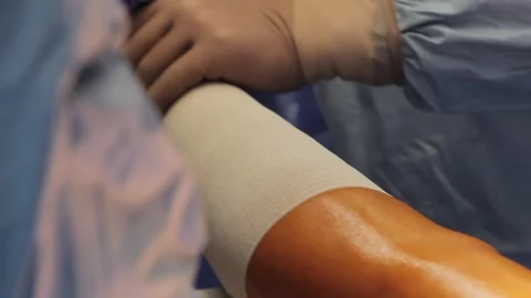 Bandaging the leg Stock Footage 295843576