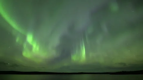 Bands and pillars aurora over lake Stock Footage 250293183