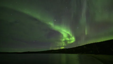 Bands of aurora behind clouds in the sandy lake bay Stock Footage 250292919