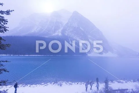 Banff, Canada, 10-26-2019: Lake Louise on winter day with tourists in front Stock Photos