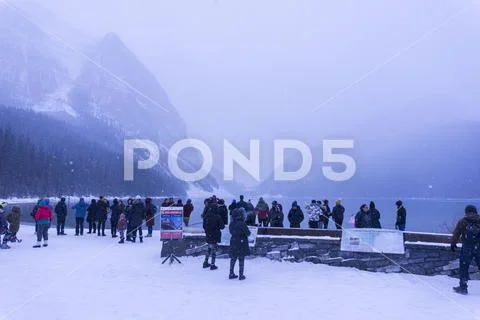 Banff, Canada, 10-26-2019: Tourists during winter in front of Lake Louise Stock Photos