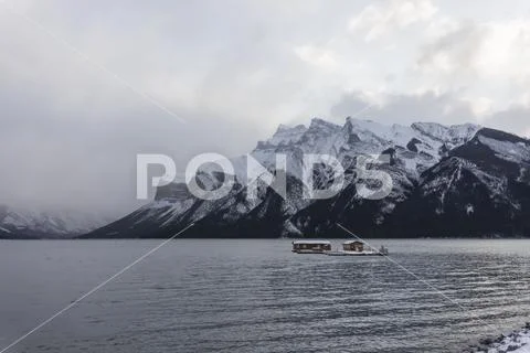 Banff, Canada, 10-28-2019: Lake Minnewanka in winter with floating building Stock Photos