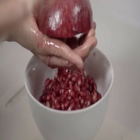 Banging the back of a Pomegranate to release the seeds.  4K UHD. Stock Footage 69702875