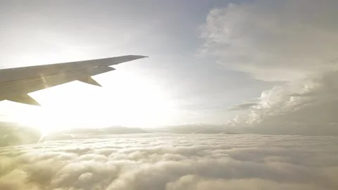 Bangking high left fly airplane wing yellow low clouds sun Stock Footage 234781313