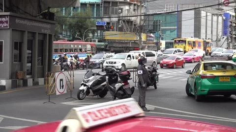 Bangkok car traffic, a policeman controls the flow of cars. Stock Footage 138774174