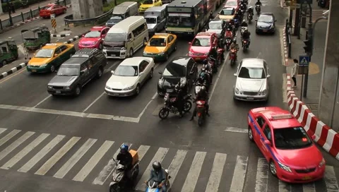 Bangkok exotic traffic with cars and motor scooters in front of intersection Stock Footage