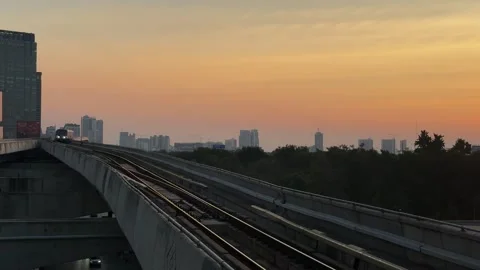 Bangkok Skytrain Approaches on Elevated Railway During Golden Hour Stock Footage 345512613