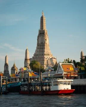 Bangkok, Thailand; May 22 2019: Wat Arun at sunset with boats Stock Photos