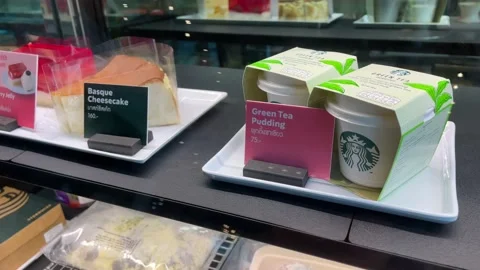 Bangkok,Green tea pudding,basque cheesecake displaying inside window Starbucks Stock Footage 232091179