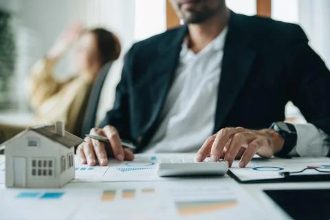 Bank loan workers are using calculators to calculate home loan interest rates Stock Photos