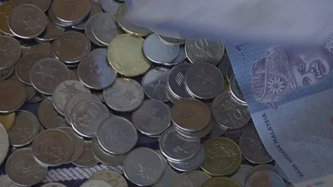 Bank Notes Falling on  a pile of coins. Malaysia Currency. Finance Concept. Stock Footage 260152106