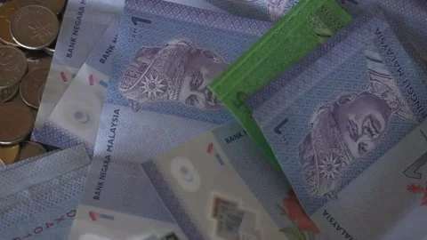 Bank Notes falling into a pile slow motion.  Malaysian Coins and Notes Stock Footage 260152101