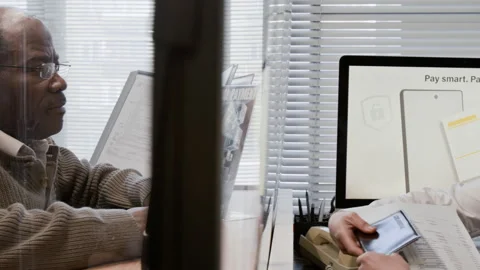 Bank Teller Helping Elderly African American Customer with Documents Stock Footage 330965273