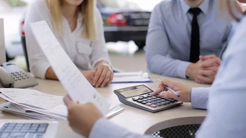 Banker Explaining The Conditions Of Housing Loans To Young Couple Stock Footage