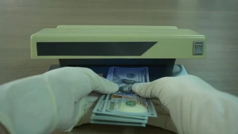 Banker hands in gloves checking for counterfeit money detecting under UV light 動画素材 307755791