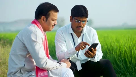 Banking officer explaining about insurance policy or crop growth from mobile Stock Footage 234886017