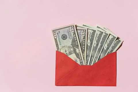 Banknotes of 100 dollars in a red envelope on a pink background.envelope with Foto stock
