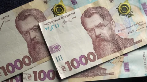 Banknotes of 1000 hryvnia fall on table. Ukrainian national currency, closeup Stock Footage 295991777
