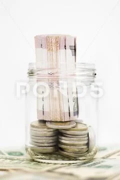 Banknotes and Coins in Glass Jar on Us Dollars, Isolated on White Background Stock Photos